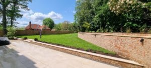Rear garden design with hard and soft landscaping works. new brick wall, patio, turf and planting 